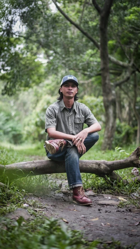 a man sitting on top of a log in the woods