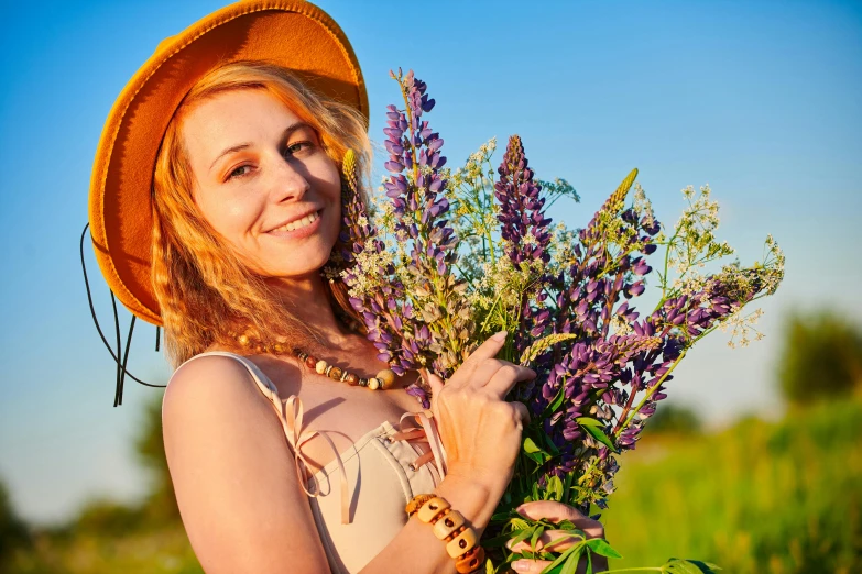 a woman wearing a sun hat holding flowers