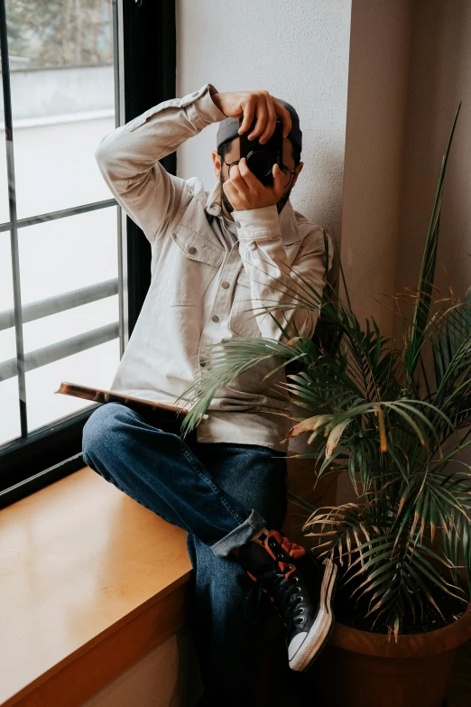 a man sitting on the side of a window sill