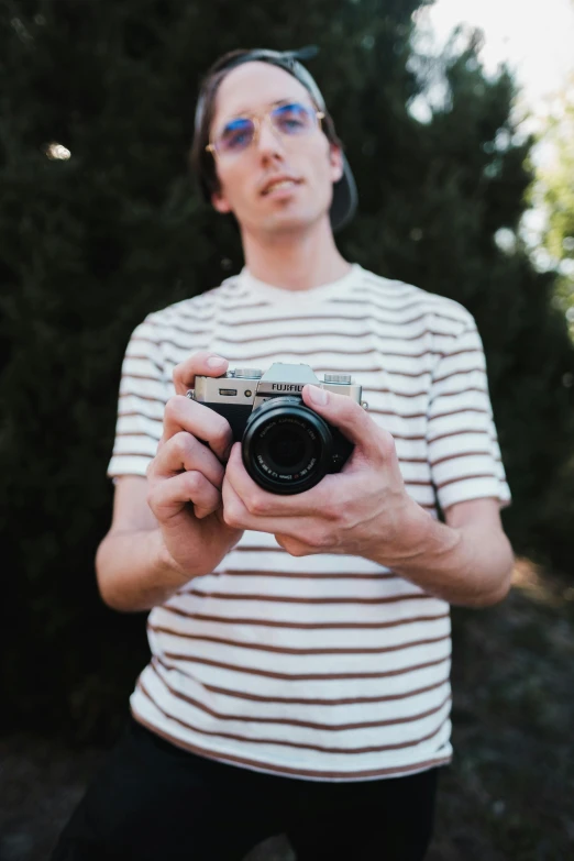 a person that is holding a camera and is wearing sunglasses