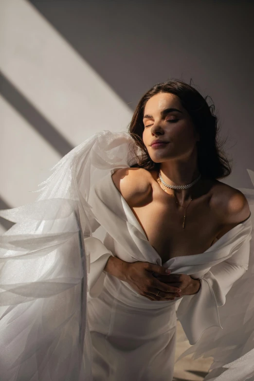 a young woman in white gown posing for the camera