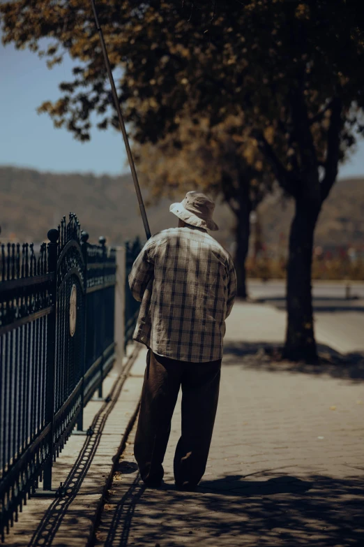 a man walks down the sidewalk with his cane