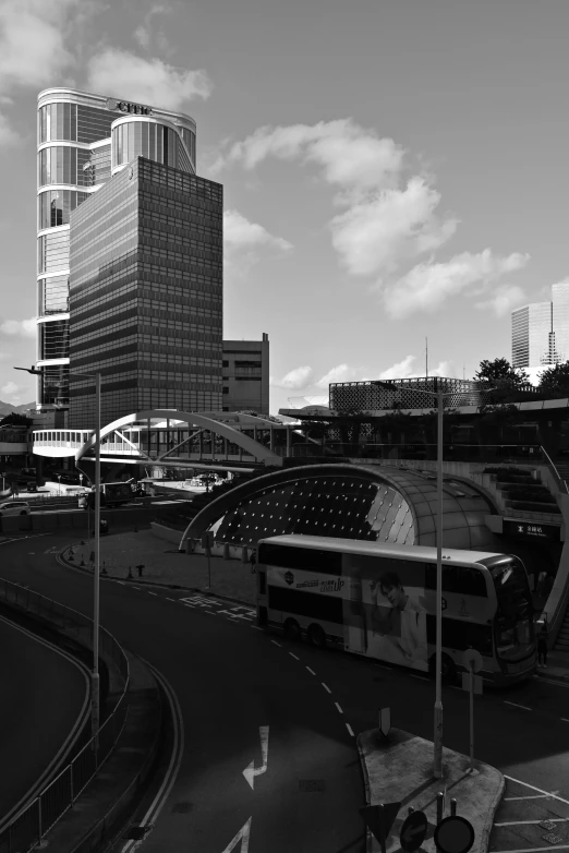 a large bus going under the bridge on a highway