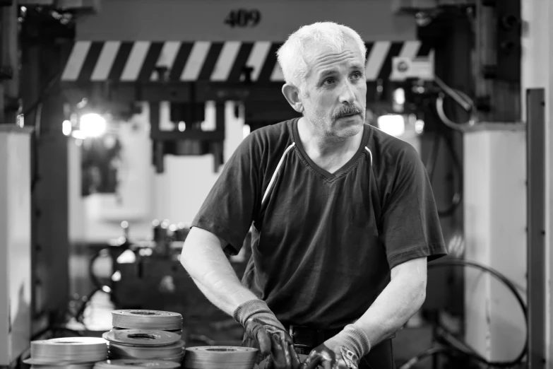 an old man stands next to stacks of plates