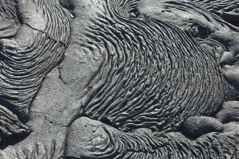 a large object in the sand, with black sand around it