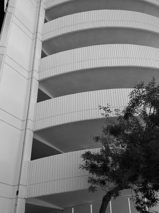 a building with a tall tree and light posts