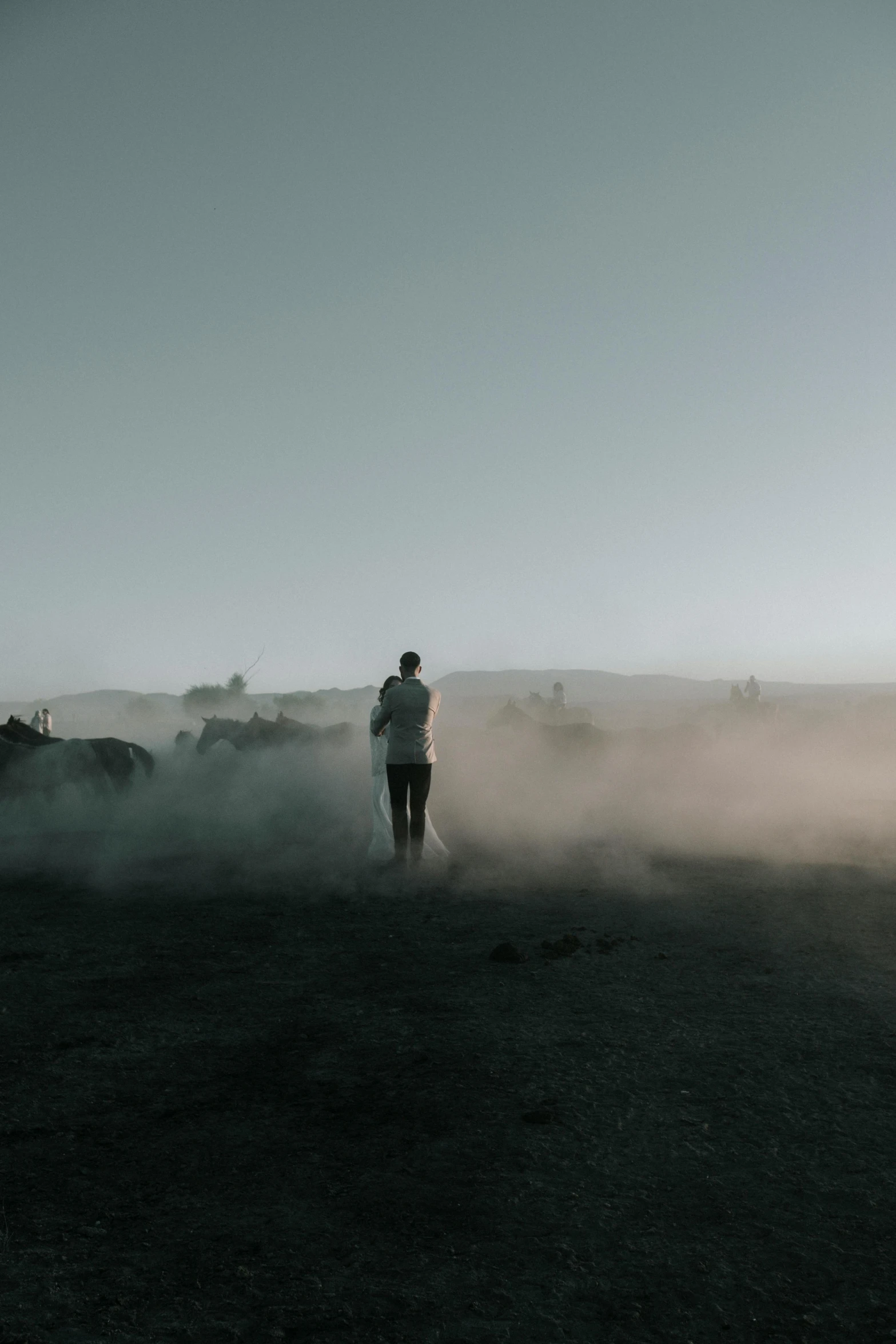 a man is watching cattle while the fog rolls in