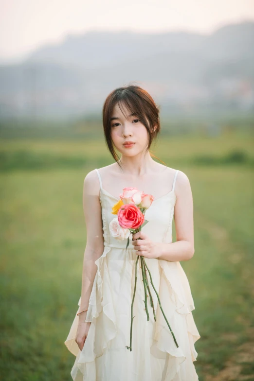 young woman in a white dress holding a flower