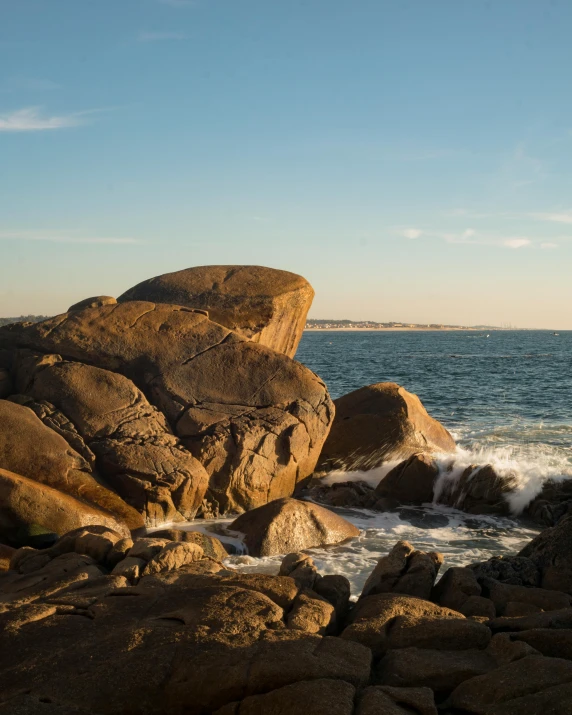 an area of rocks next to the water with waves on them