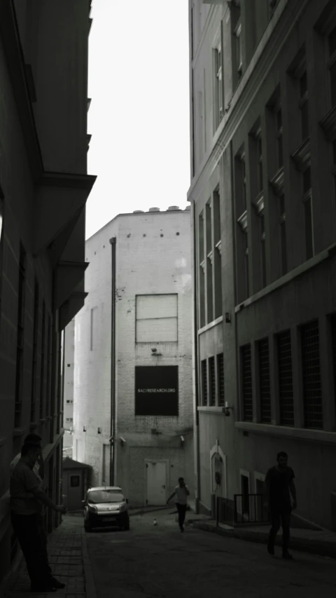 two people walking on the street with building in the background