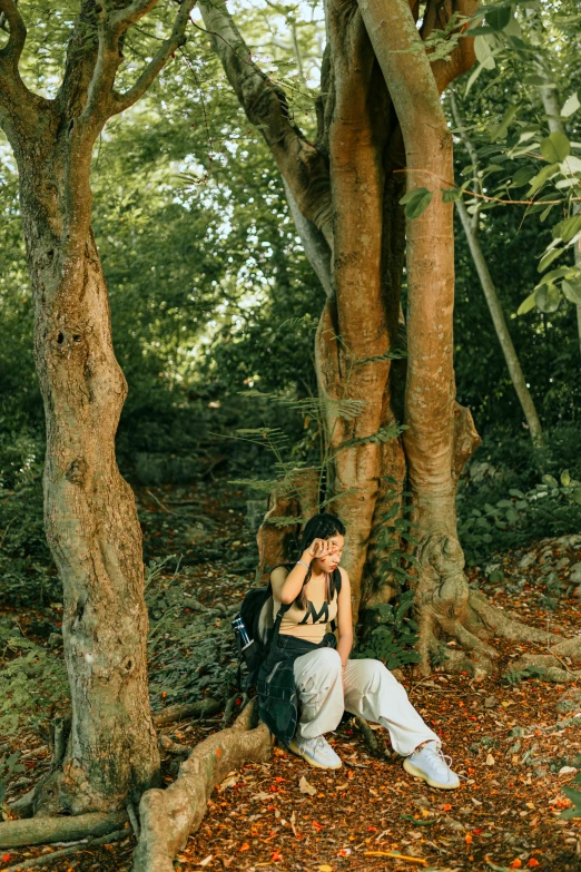 a beautiful young woman sitting on top of a tree