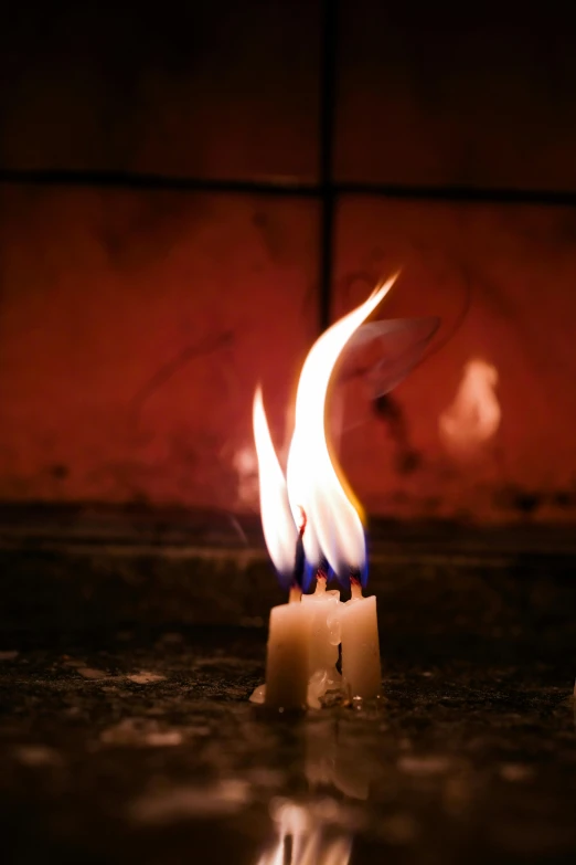 some candles flame and water in a bathroom