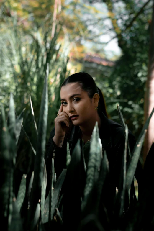 a young woman talks on her cell phone near many plants