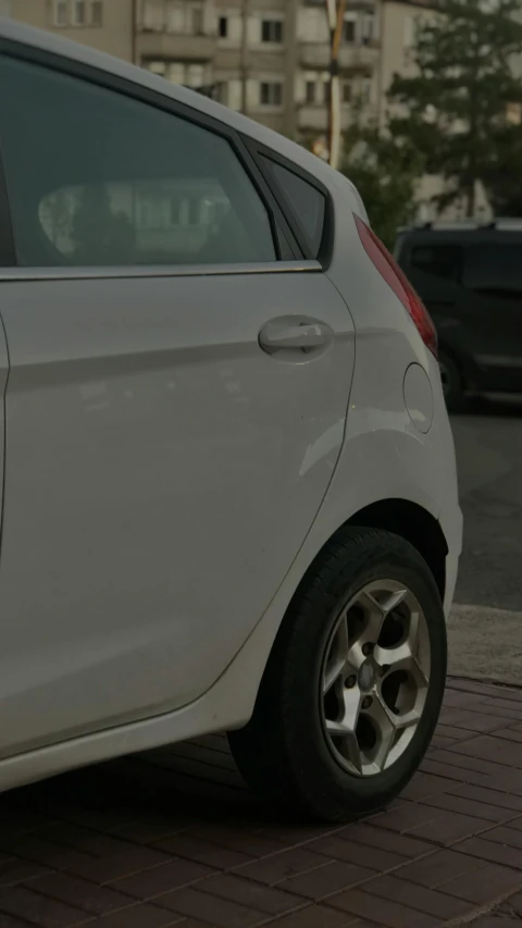 a silver car parked on the side of the road next to a building