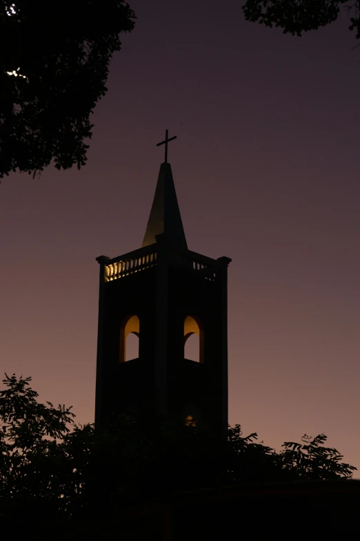 a small church steeple is illuminated by the light of a candle