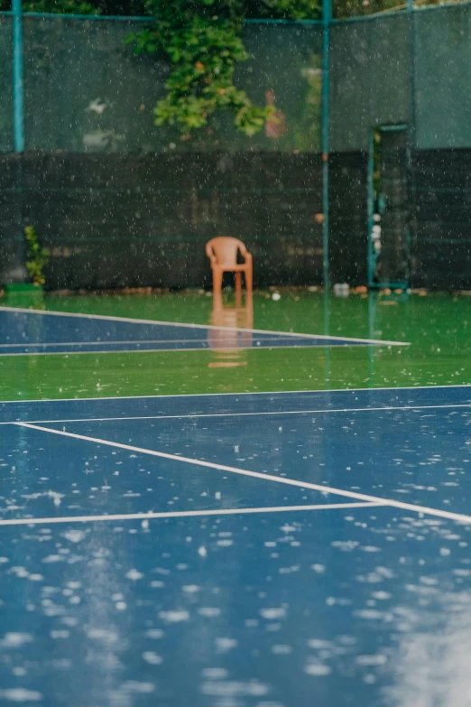 a small brown chair sitting on top of a tennis court