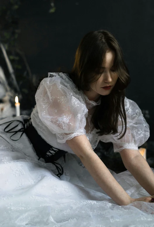 a woman in a white dress is laying on a bed