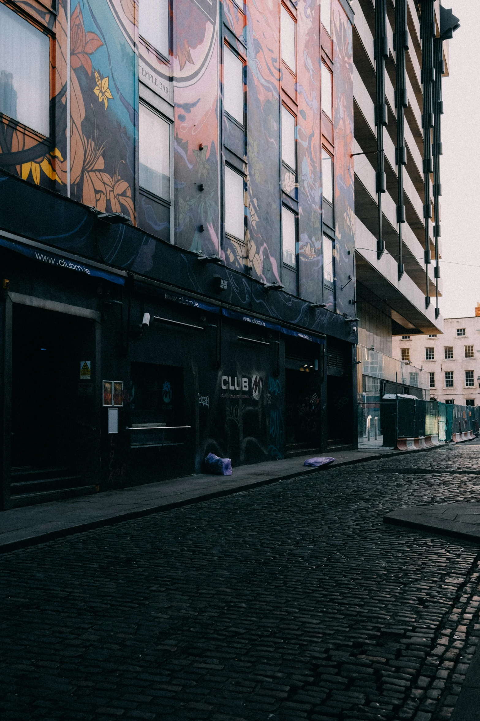 an empty bricked street near buildings in the sun