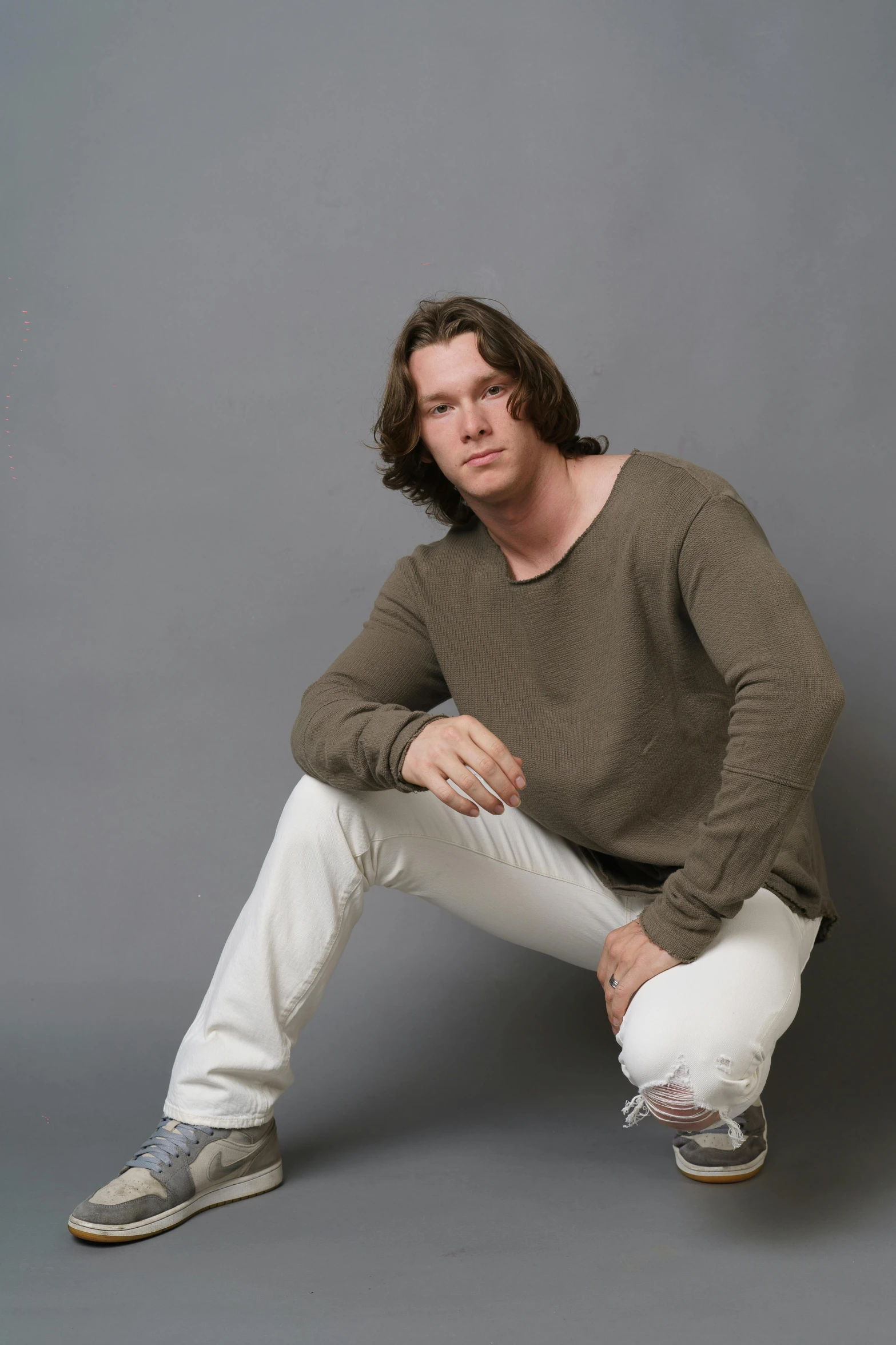 an image of a man sitting down with his hands on his knees