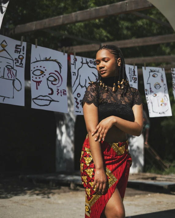 woman wearing a skirt standing in front of some drawings