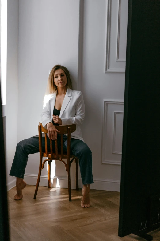 a woman sitting on top of a wooden chair