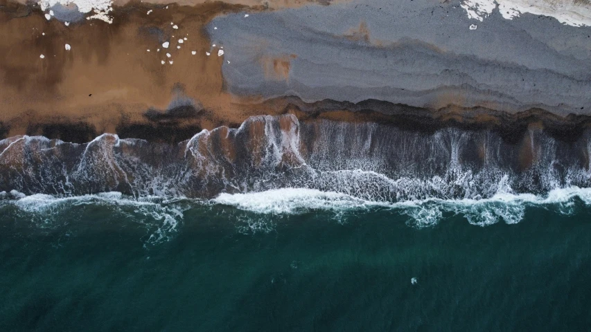 an overhead view of the water with rocky cliffs