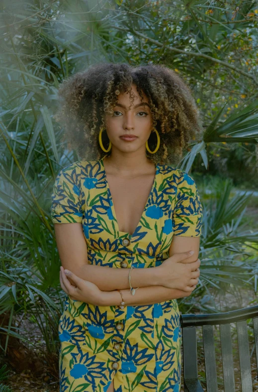 woman in a yellow and blue dress posing with her arms crossed