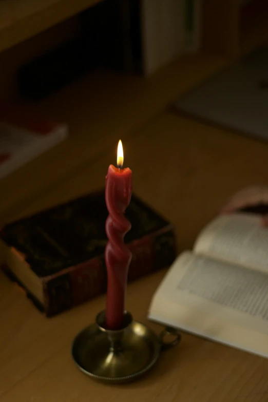 a lit candle sitting on top of a metal cup