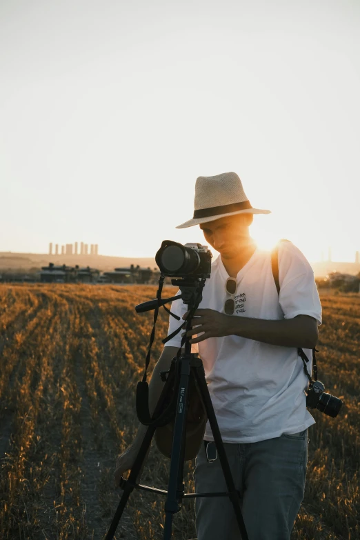 a man standing on a field holding a camera