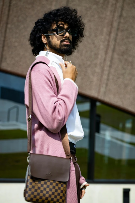 a person wearing a pink sweater carrying a brown bag