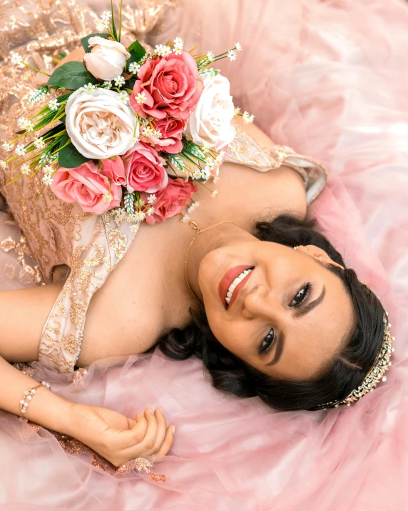 a woman laying on a pink blanket with flowers