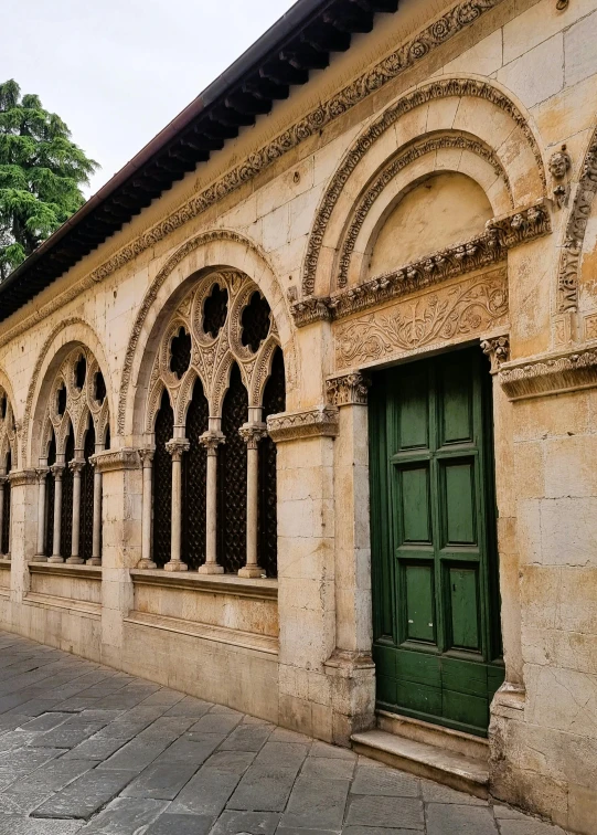 a building with arched windows and a green door