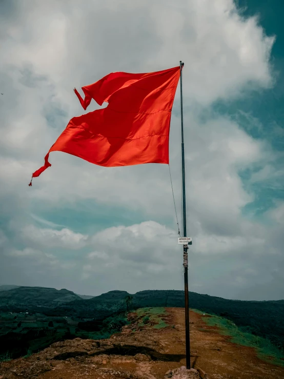 the red flag is waving at the top of a mountain