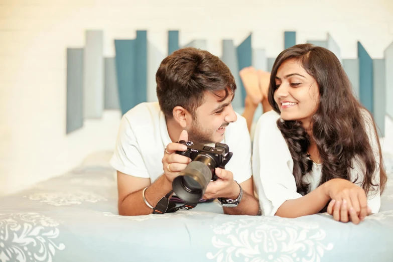 the man and woman are smiling at each other while laying on the bed