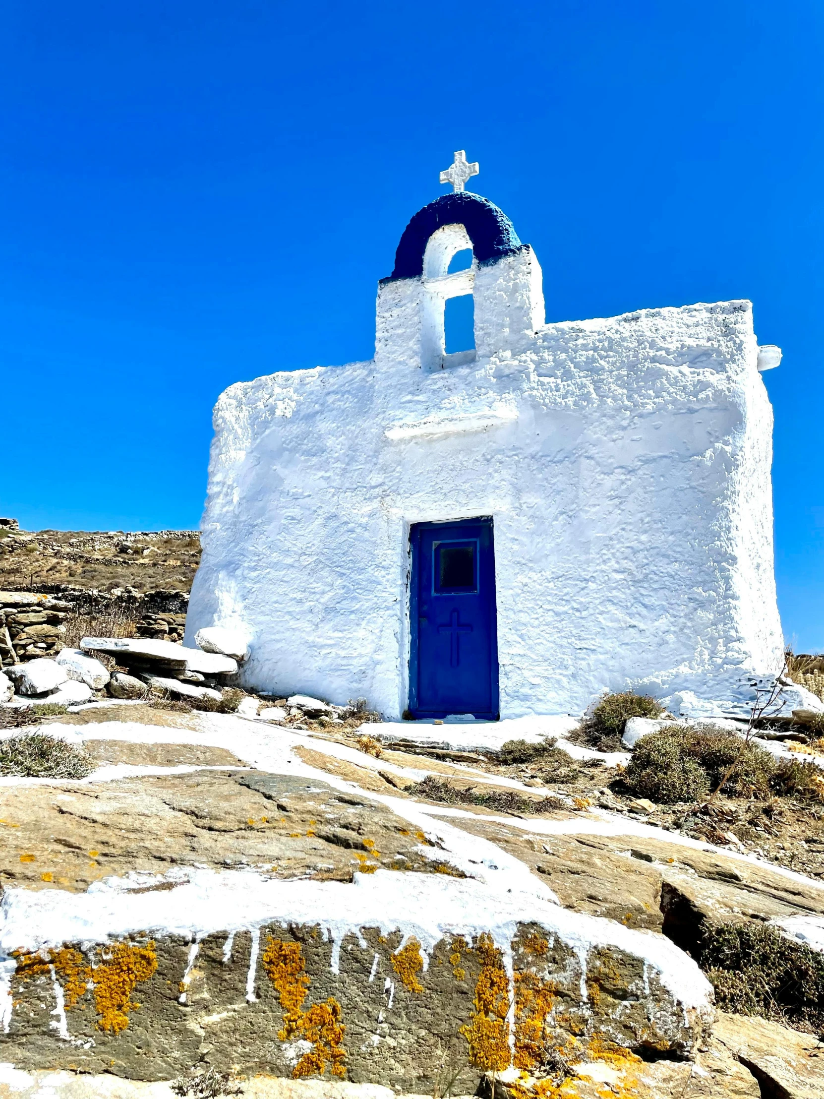 a small white building with blue door on the side