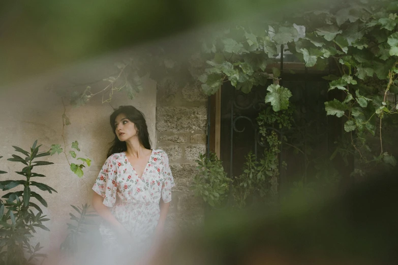 woman standing next to wall covered in ivy