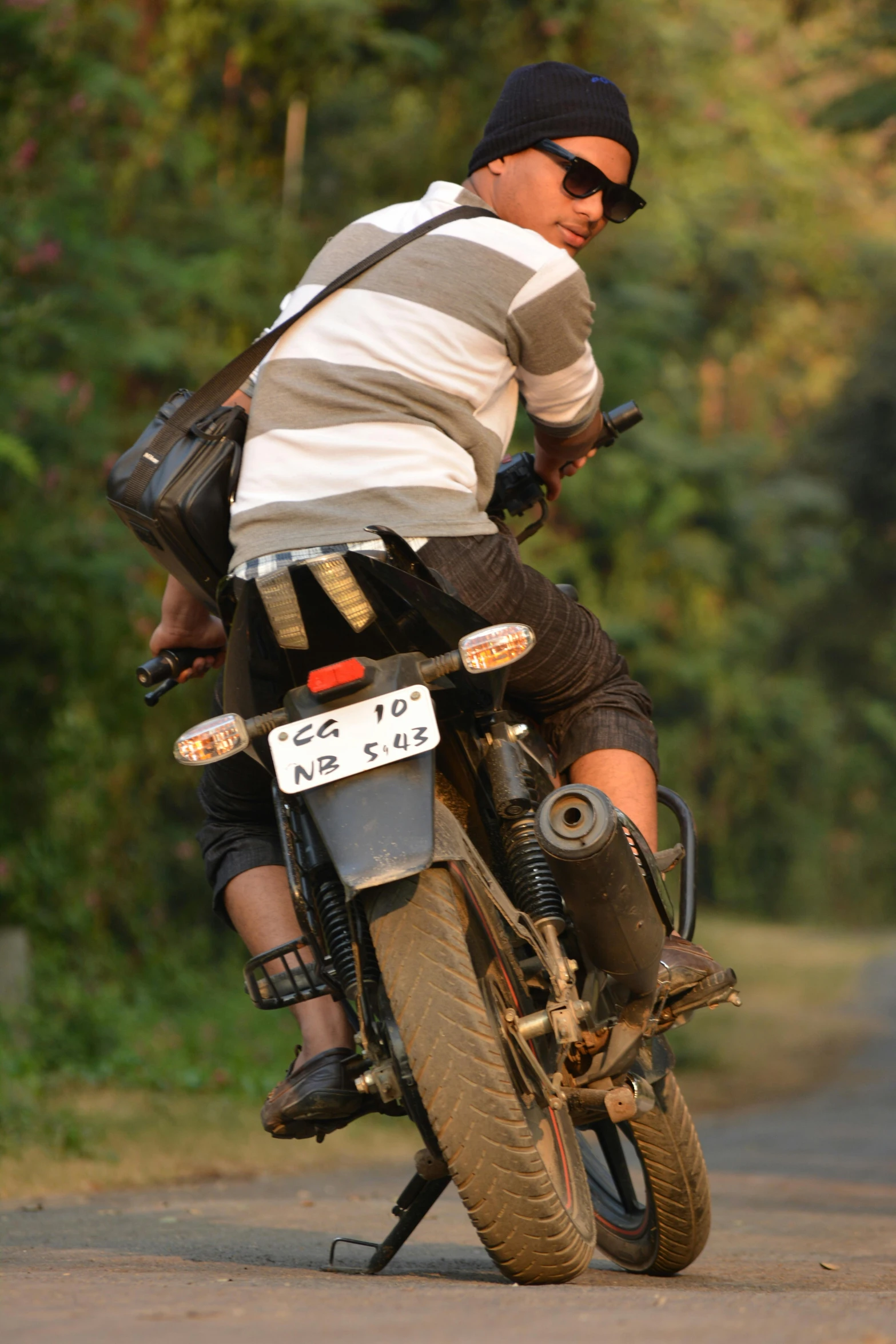 a man riding on the back of a motorcycle down a street