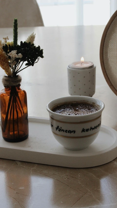 small bowl on tray near candlelight and decorative container