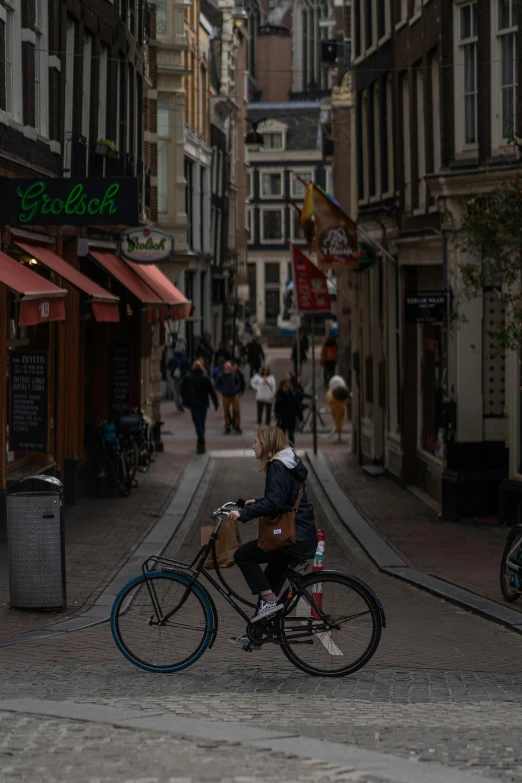 a woman on a bike rides down a city street