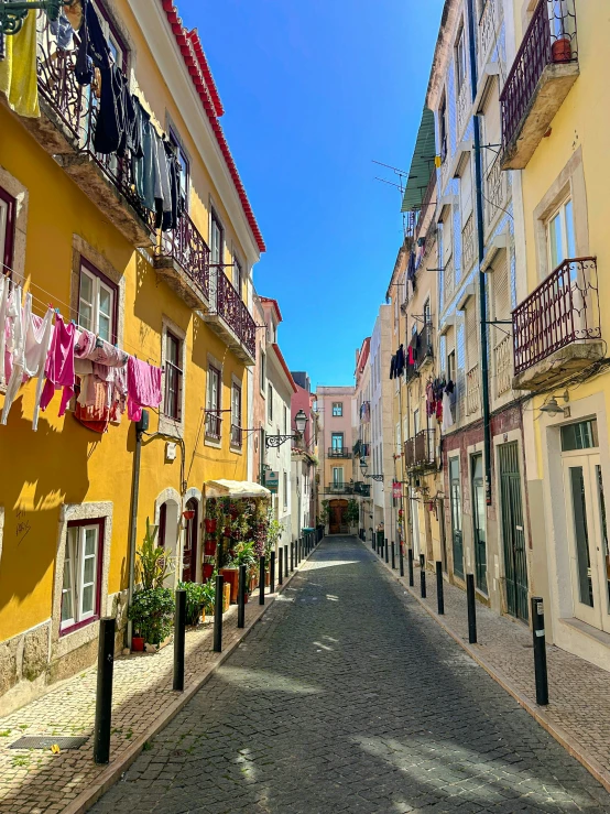 a narrow city street with colorful buildings and balconies