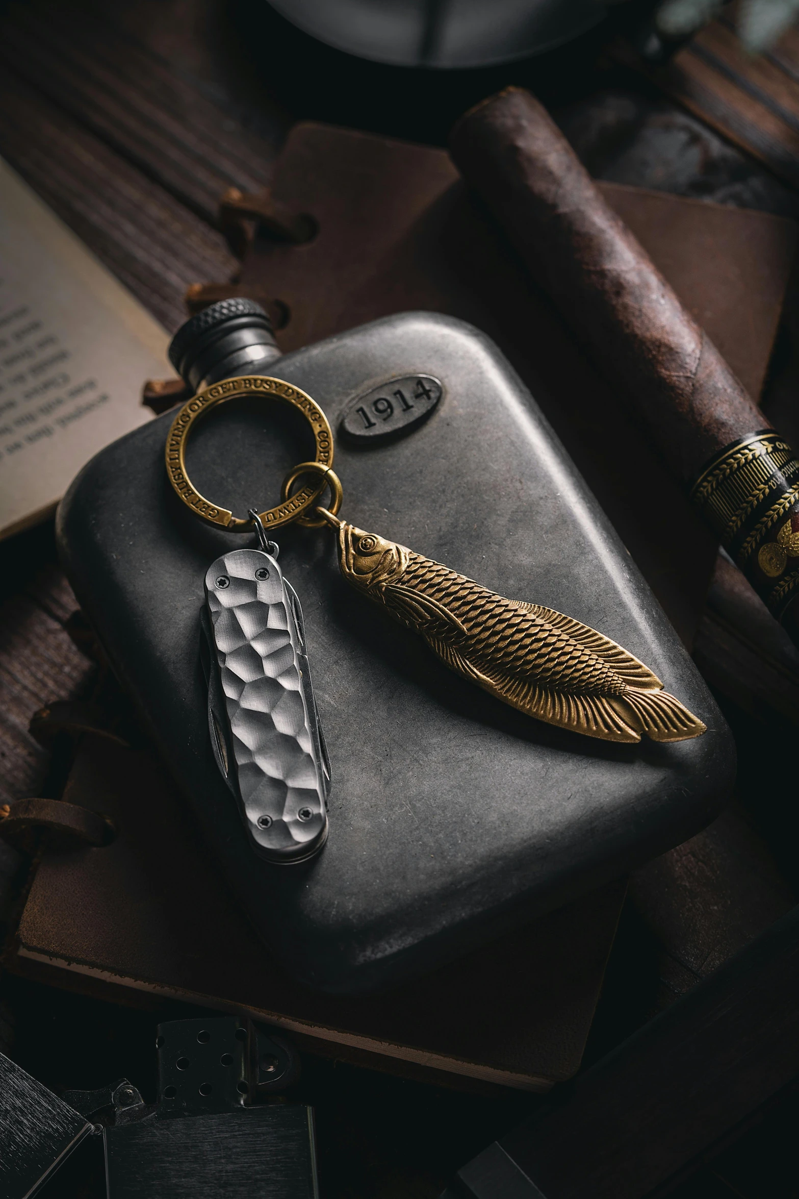 a metal keychain with a gold - plated feather on top