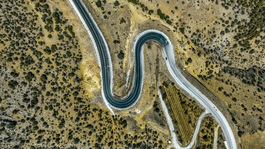 aerial view of curving road winding through a deserted area