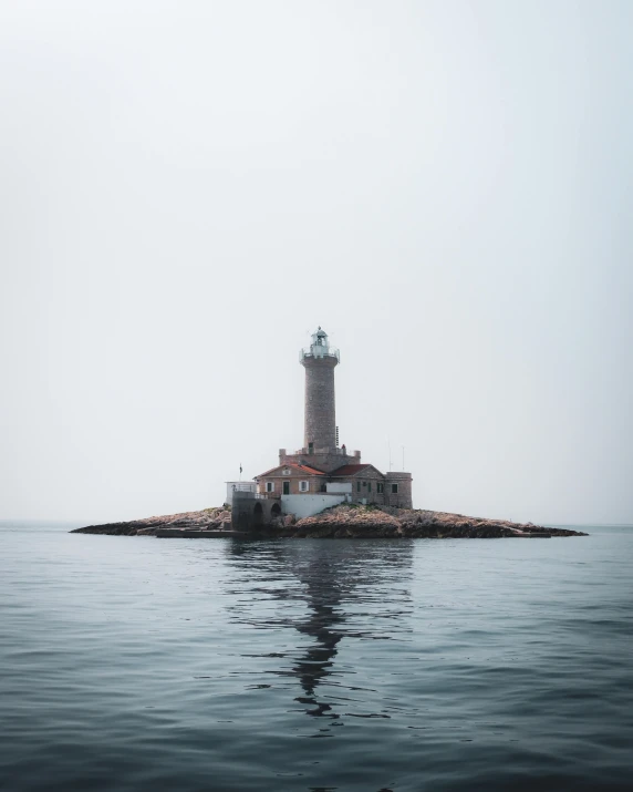 a large boat sails in front of a lighthouse on an island