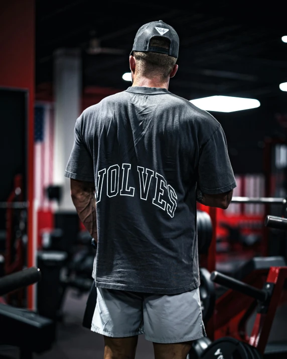 a man with a cap stands in front of some weight benches