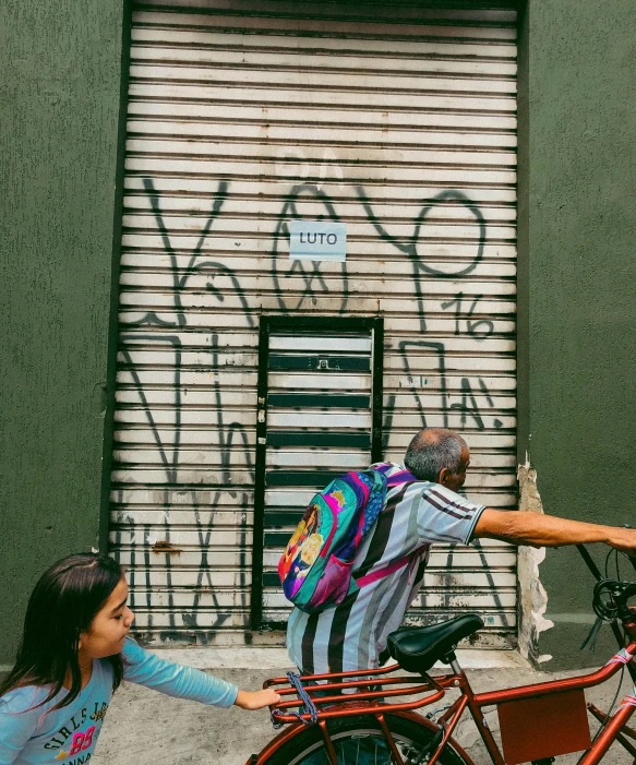 an old man hing his bike to a closed shop