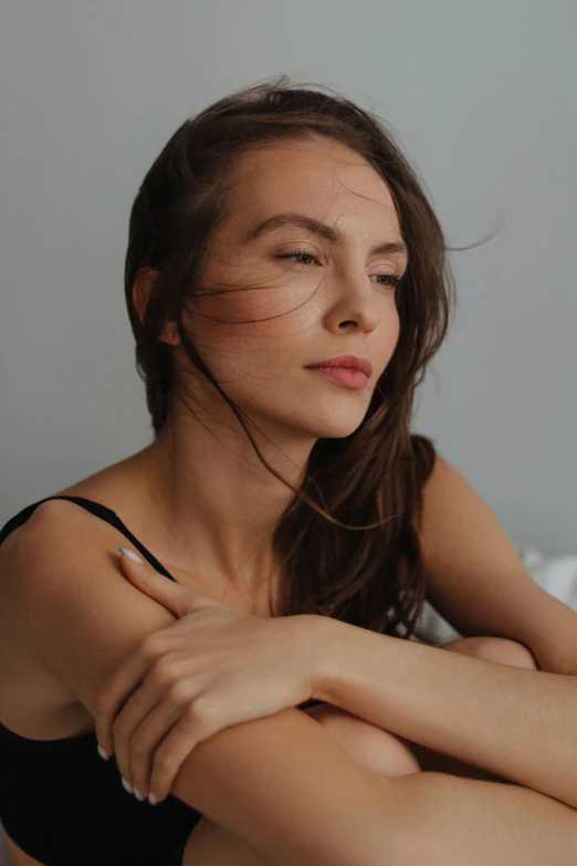 woman with arm folded laying on her bed