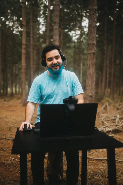 man in headphones sitting on top of an open laptop