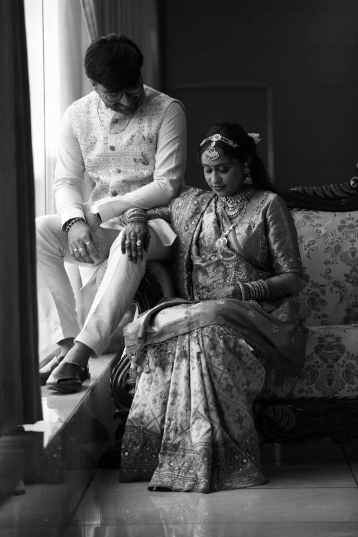 a man and woman sitting on top of a couch