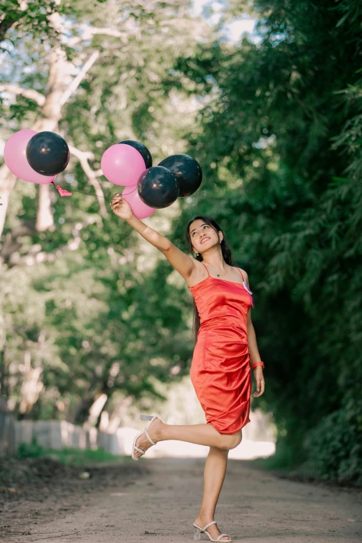 a young lady in a short dress is jumping up with balloons