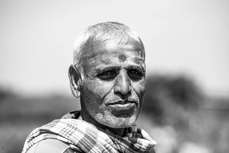 a man with a white hair and brown eyes wearing a plaid towel